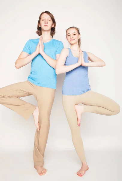 Estilo de vida, esporte e conceito de pessoas: Jovem casal em pose de ioga — Fotografia de Stock