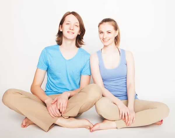 Estilo de vida, esporte e conceito de pessoas: Jovem casal em pose de ioga — Fotografia de Stock