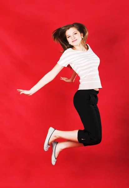 Girl jumping of joy over red — Stock Photo, Image