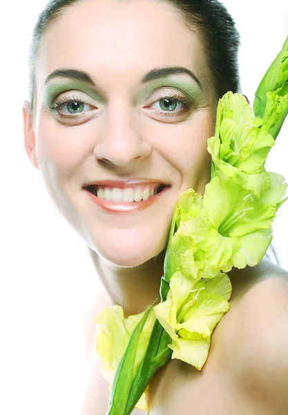 Visage frais avec des fleurs de gladiole dans ses mains — Photo