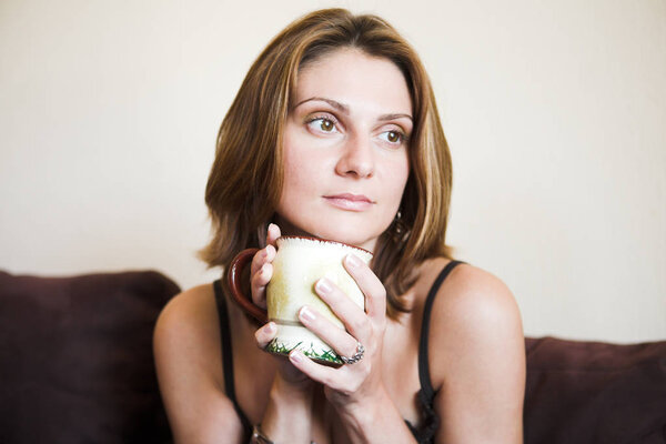 Portrait of young beautiful woman with tea