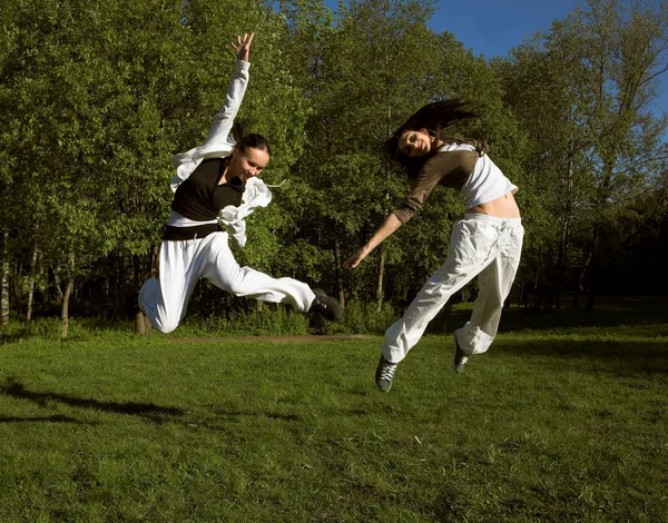 Twee meisje springen in park — Stockfoto