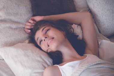 Genç kadın yatakta uyuyor.
