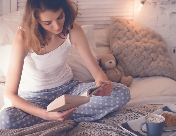 Meisje in bed lezen en koffie drinken — Stockfoto