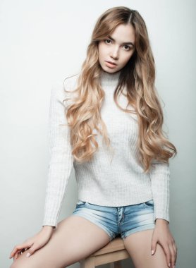 Yaşam tarzı, moda ve insan konsepti: güzel kadın günlük kıyafetler giyiyor, beyaz arka planda poz veriyor.