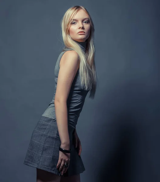 Portret van mooi jong blond meisje in zwarte jurk. — Stockfoto