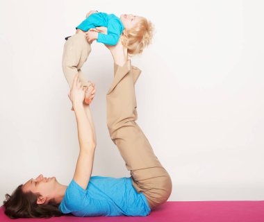 Spor ve insanlar kavramı: baba ve oğlu yoga yaparken egzersiz studio beyaz arka plan üzerinde.