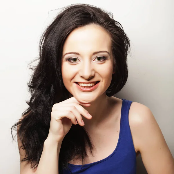 Beyaz arka planda gülümseyen güzel esmer kız.