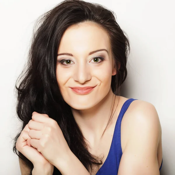 Beyaz arka planda gülümseyen güzel esmer kız.