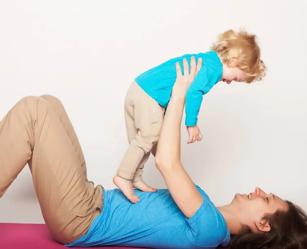 Sport en mensen concept: vader en haar zoon doen yoga oefening op studio witte achtergrond. — Stockfoto