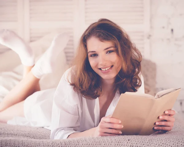 Yaşam tarzı ve insan konsepti: Genç kadın okurken yatakta yatıyor — Stok fotoğraf