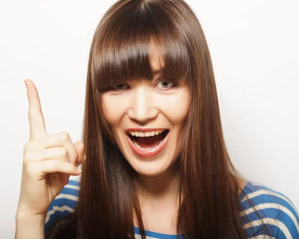 Estilo de vida e conceito de pessoas: mulher feliz poiting dedo para cima em um — Fotografia de Stock