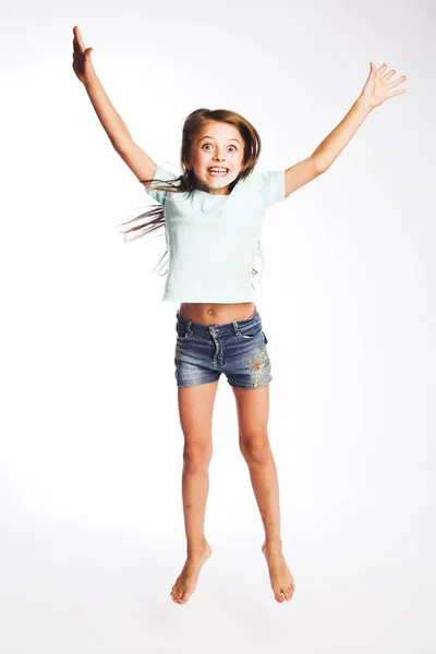 Menina salta em um fundo branco — Fotografia de Stock