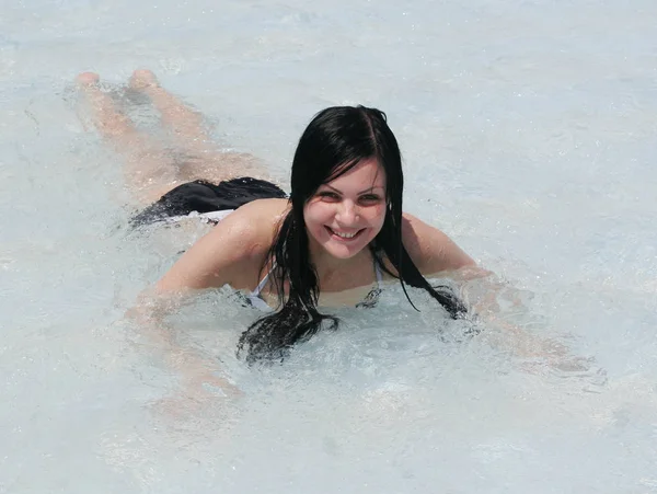 Νεαρή γυναίκα, χαμογελαστά σε μια πισίνα — Φωτογραφία Αρχείου