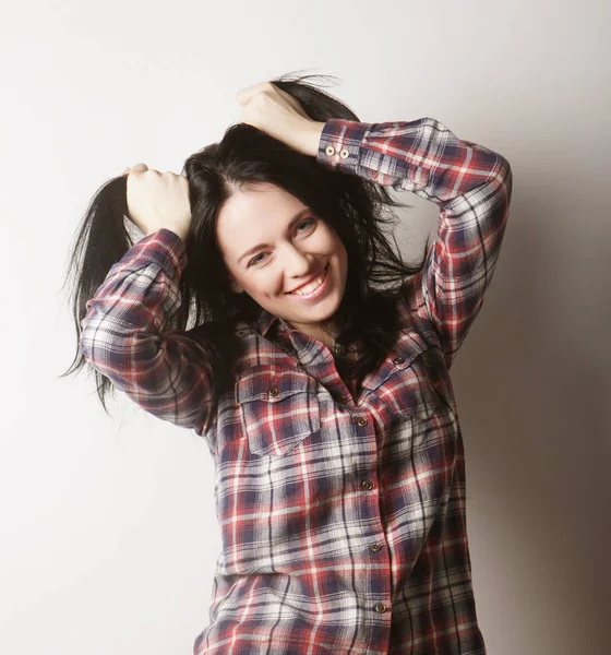 Kadın günlük kıyafetler giyiyor, beyaz arka planda poz veriyor.