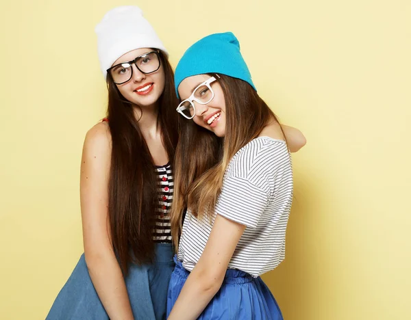 Estilo de vida y el concepto de la gente: Dos amigas jóvenes de pie a — Foto de Stock