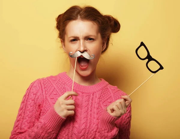 Mujer joven con bigotes falsos y gafas sobre fondo amarillo — Foto de Stock