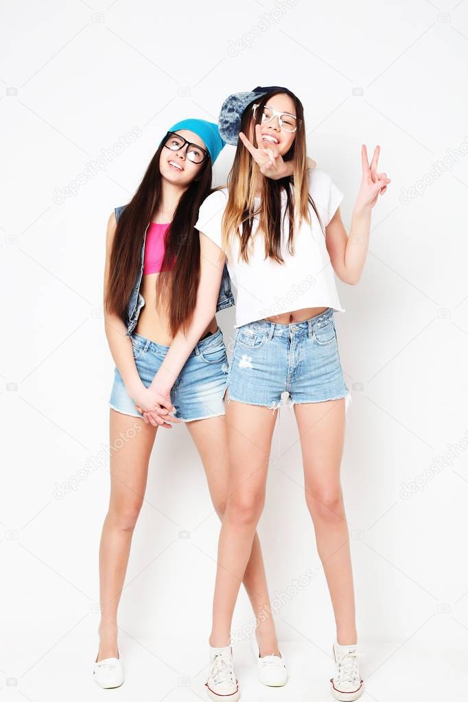 Full body portrait of two hipster girls over white background