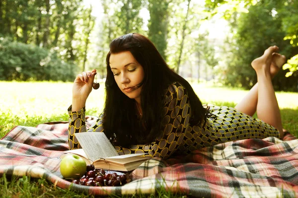 Belle jeune femme lisant en plein air — Photo