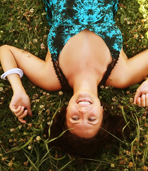 çimenlerin üzerinde genç gülümseyen kadın