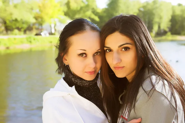 Duas mulheres jovens junto ao lago se divertindo — Fotografia de Stock