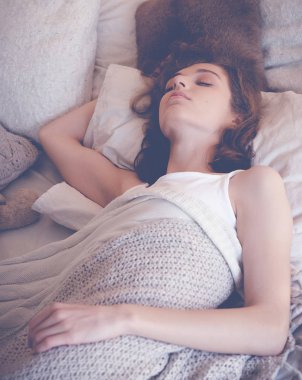 Genç kadın yatakta uyuyor.