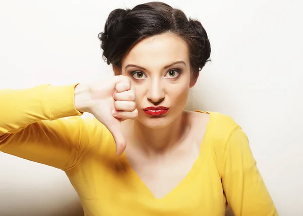 Young woman points down with finger — Stock Photo, Image