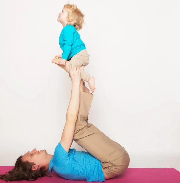 Esporte e conceito de pessoas: pai e seu filho fazendo exercício de ioga no estúdio fundo branco . — Fotografia de Stock