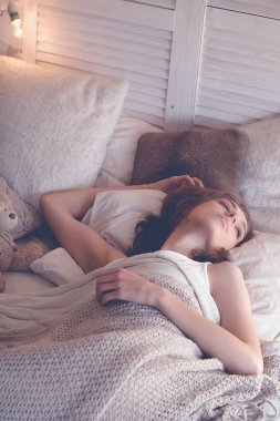 Genç kadın yatakta uyuyor.