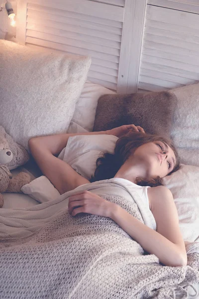 Genç kadın yatakta uyuyor.