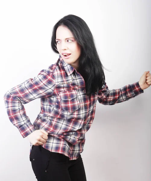 Kadın günlük kıyafetler giyiyor, beyaz arka planda poz veriyor.