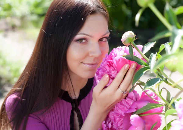 Mulher sorrindo ao ar livre com algumas flores — Fotografia de Stock