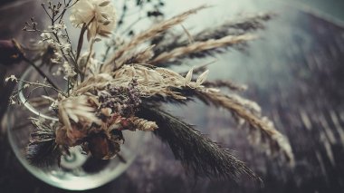 Masanın üzerinde kurumuş çiçekler var.