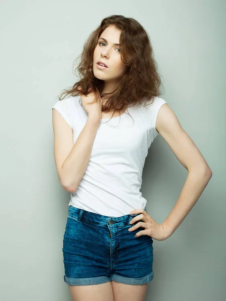 Estilo de vida, moda y concepto de la gente: mujer rizada joven posando en el estudio — Foto de Stock