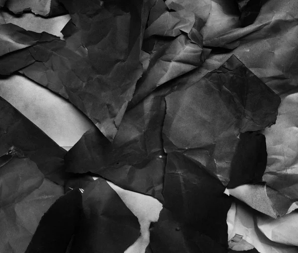 Hintergrund aus zerknüllten Papierfragmenten, schwarz-weiß — Stockfoto