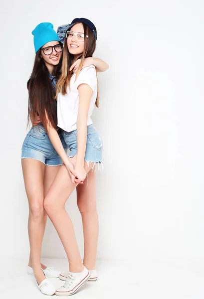 Hela kroppen porträtt av två hipster flickor över vit bakgrund — Stockfoto