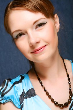 mavi bir arka plan üzerinde poz bir mavi elbiseli kadın