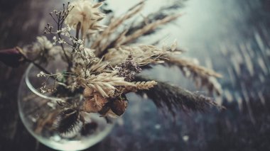 Masanın üzerinde kurumuş çiçekler var.