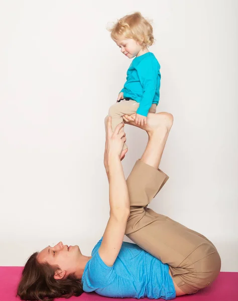 Esporte e conceito de pessoas: pai e seu filho fazendo exercício de ioga no estúdio fundo branco . — Fotografia de Stock