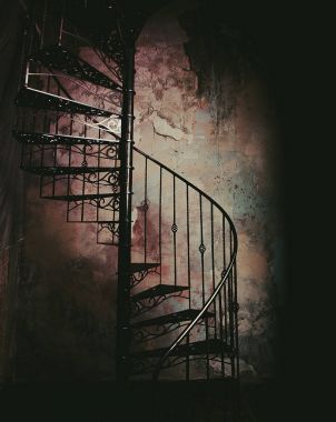 Metal spiral merdiven, eski duvar zeminine karşı.