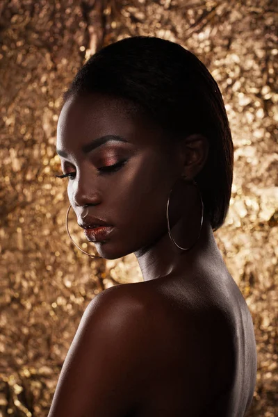 Modestudio Porträt eines außergewöhnlich schönen afrikanisch-amerikanischen Modells mit geschlossenen Augen vor goldenem Hintergrund — Stockfoto