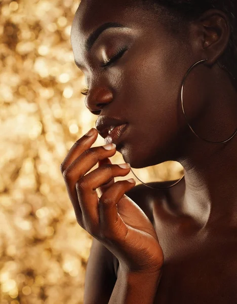 Portrait of sensual young african woman against golden background — Stock Photo, Image