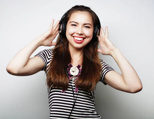 Ung kvinna lyssnar på musik. Glada och hörlurar. — Stockfoto