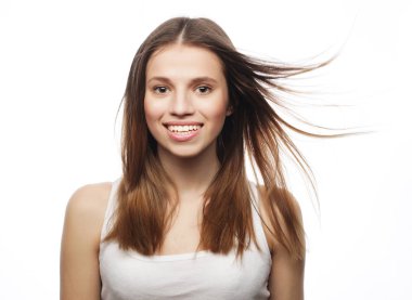 Beyaz arka planda gülümseyen sarışın genç kız.