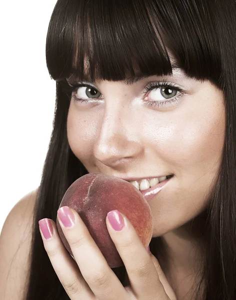 Beautiful young woman eating a peach. — Stock Photo, Image