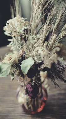 Masanın üzerinde kurumuş çiçekler var.