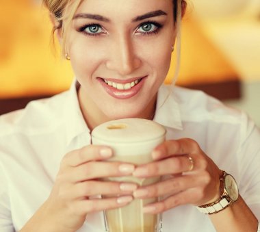 Sabahları restoranda kahve içen bir kadın.