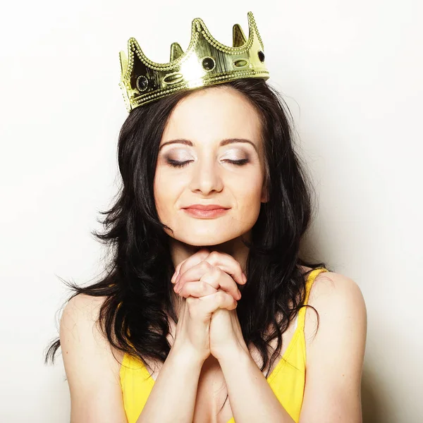 Güzel esmer kadın taç takıyor.