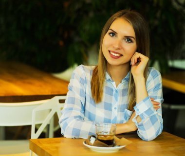 Sabahları restoranda kahve içen bir kadın.