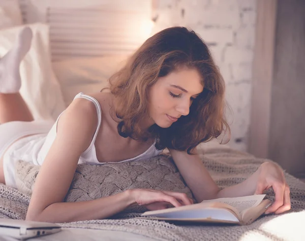 beautiful blond woman reading book in the bed. Relaxing concept